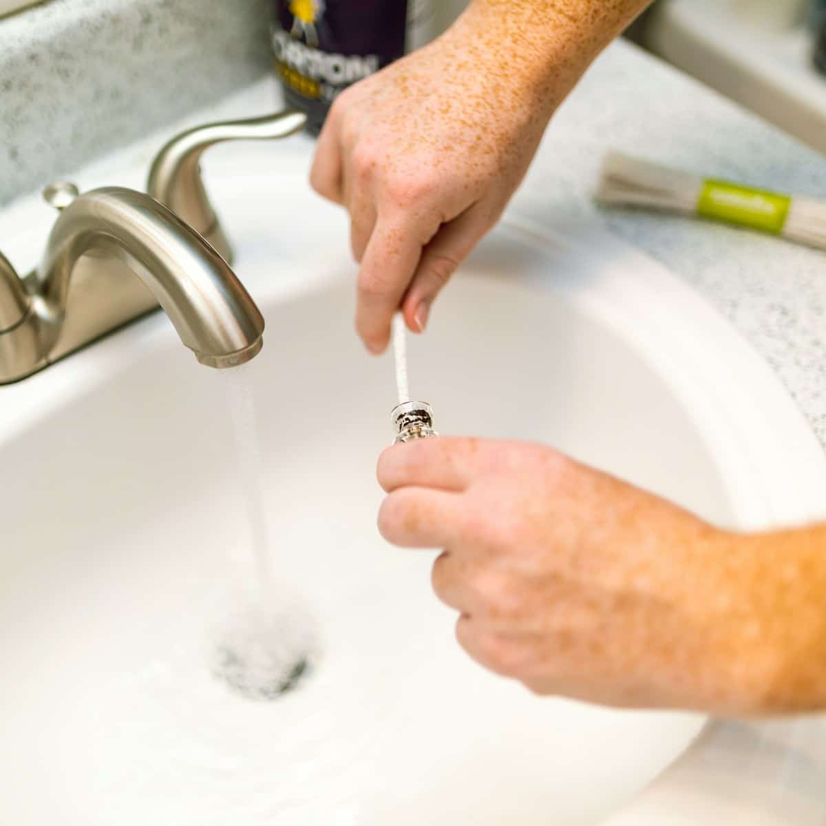 person holding silver steel faucet